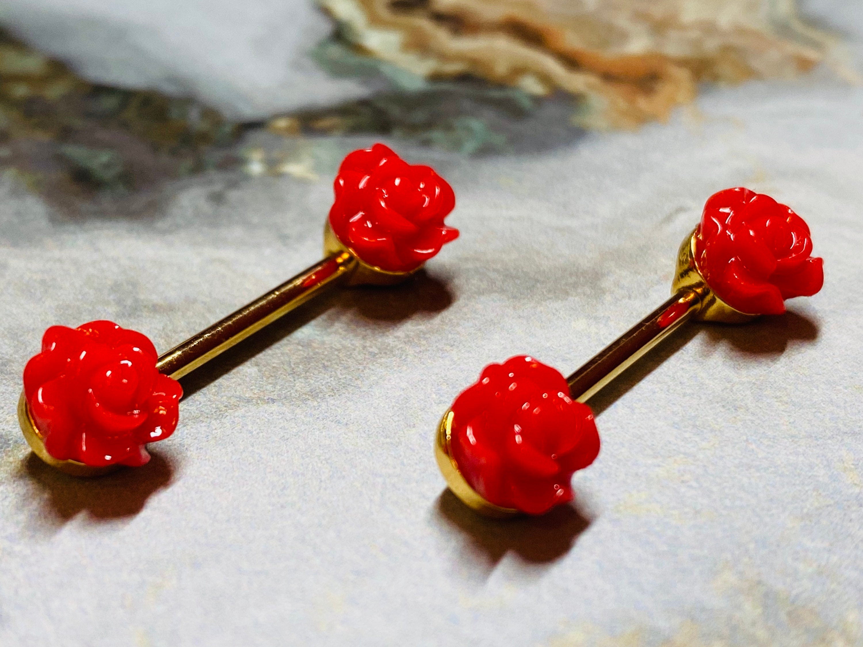 A set of Red Acrylic Rose Nipple Barbell