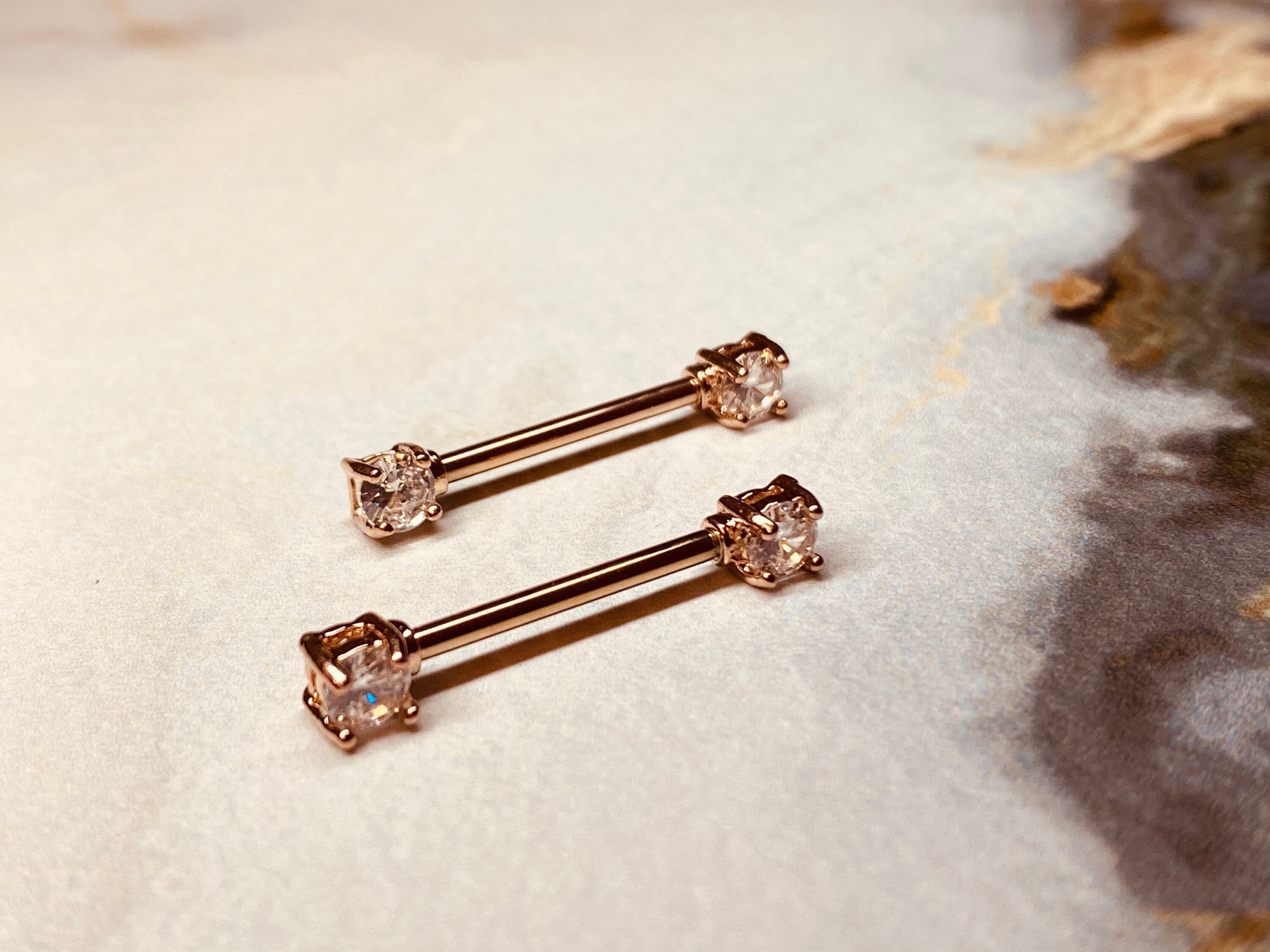 A set of Prong Set Rose Gold Clear Cubic Zirconia Nipple Barbell