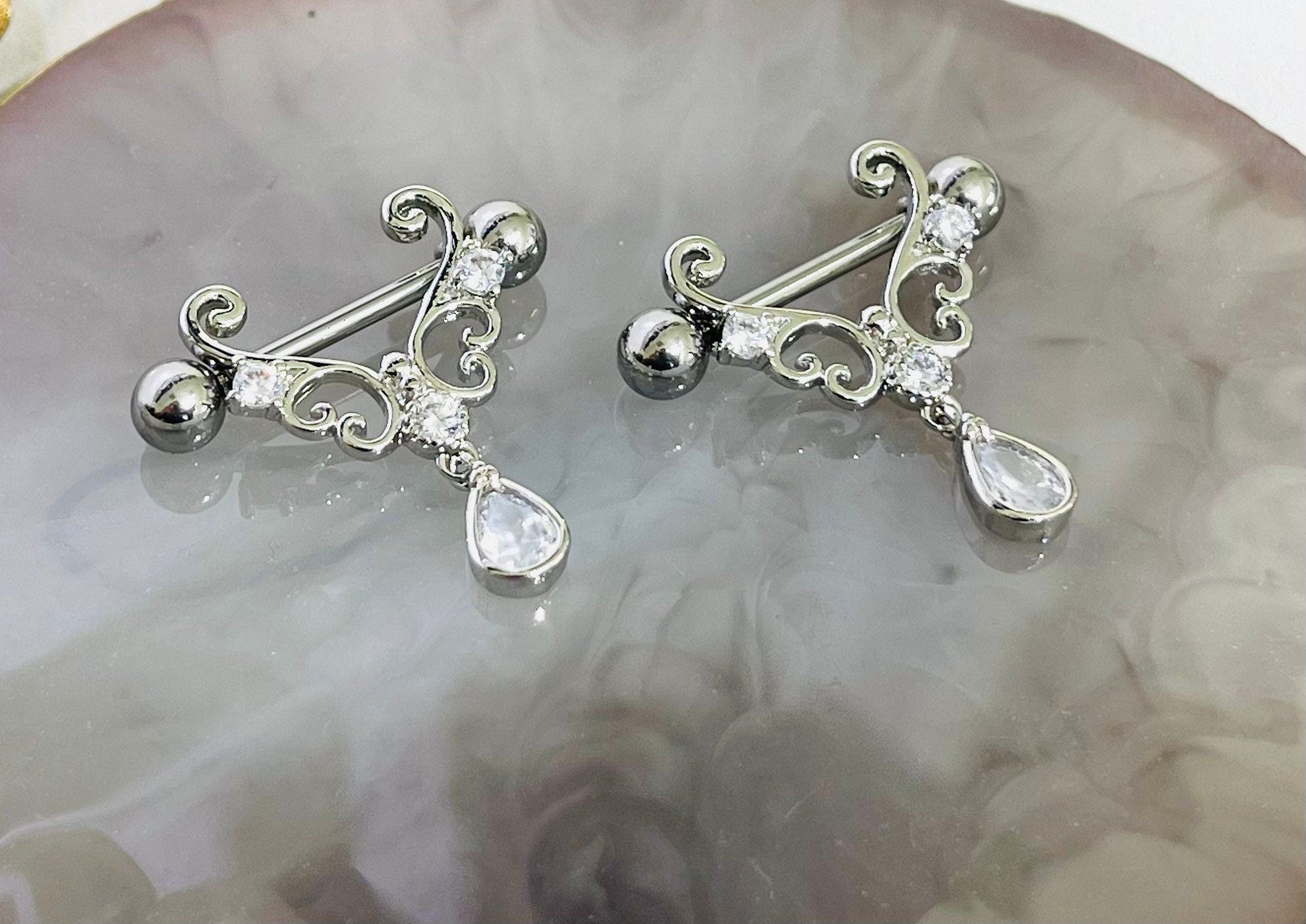 Pair of 14G Silver Heart Filigree with Dangling Teardrop Nipple Barbell.