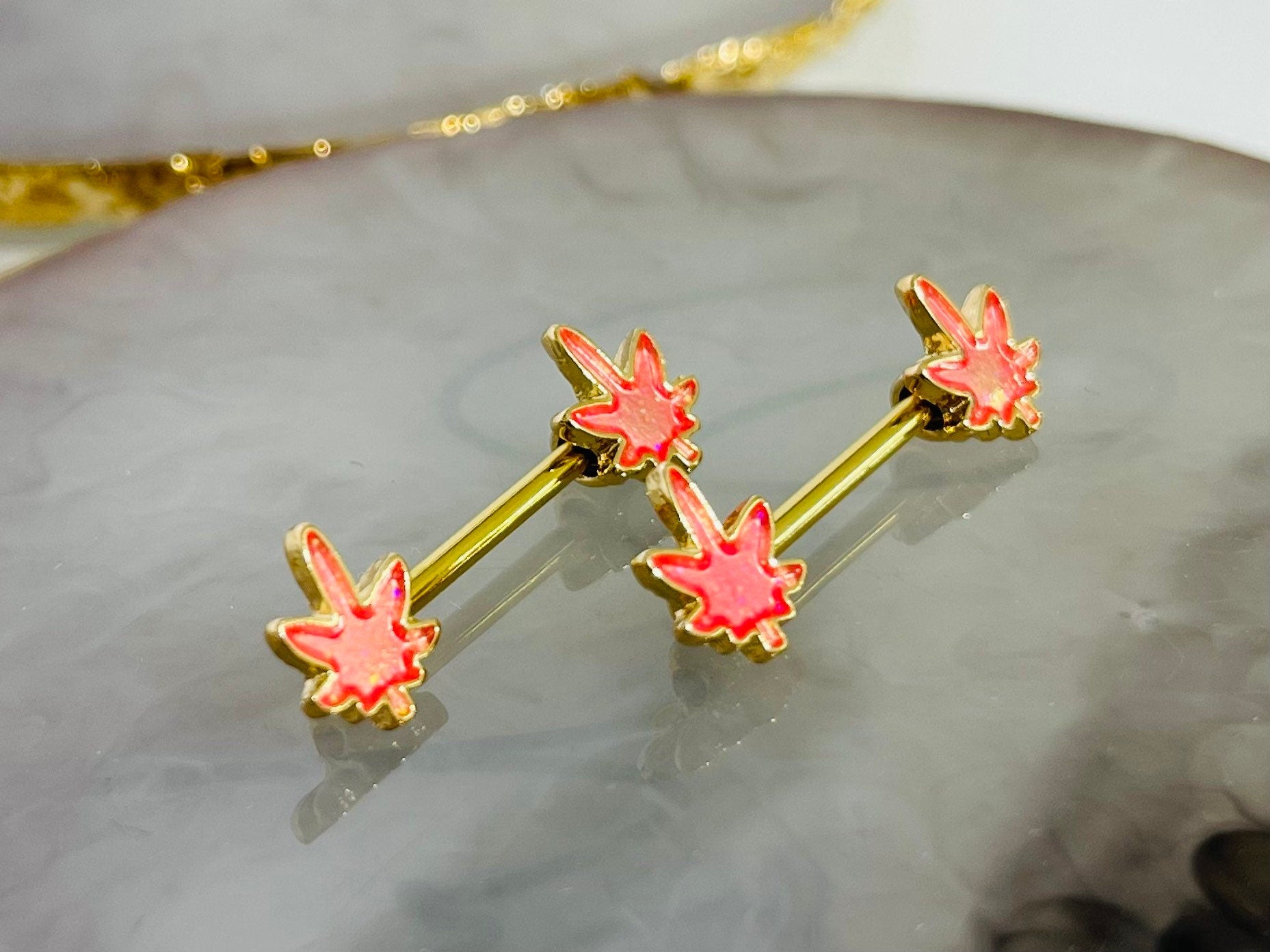 Pair of 14G Gold Pink Glitter Marijuana Leaf Nipple Barbell.